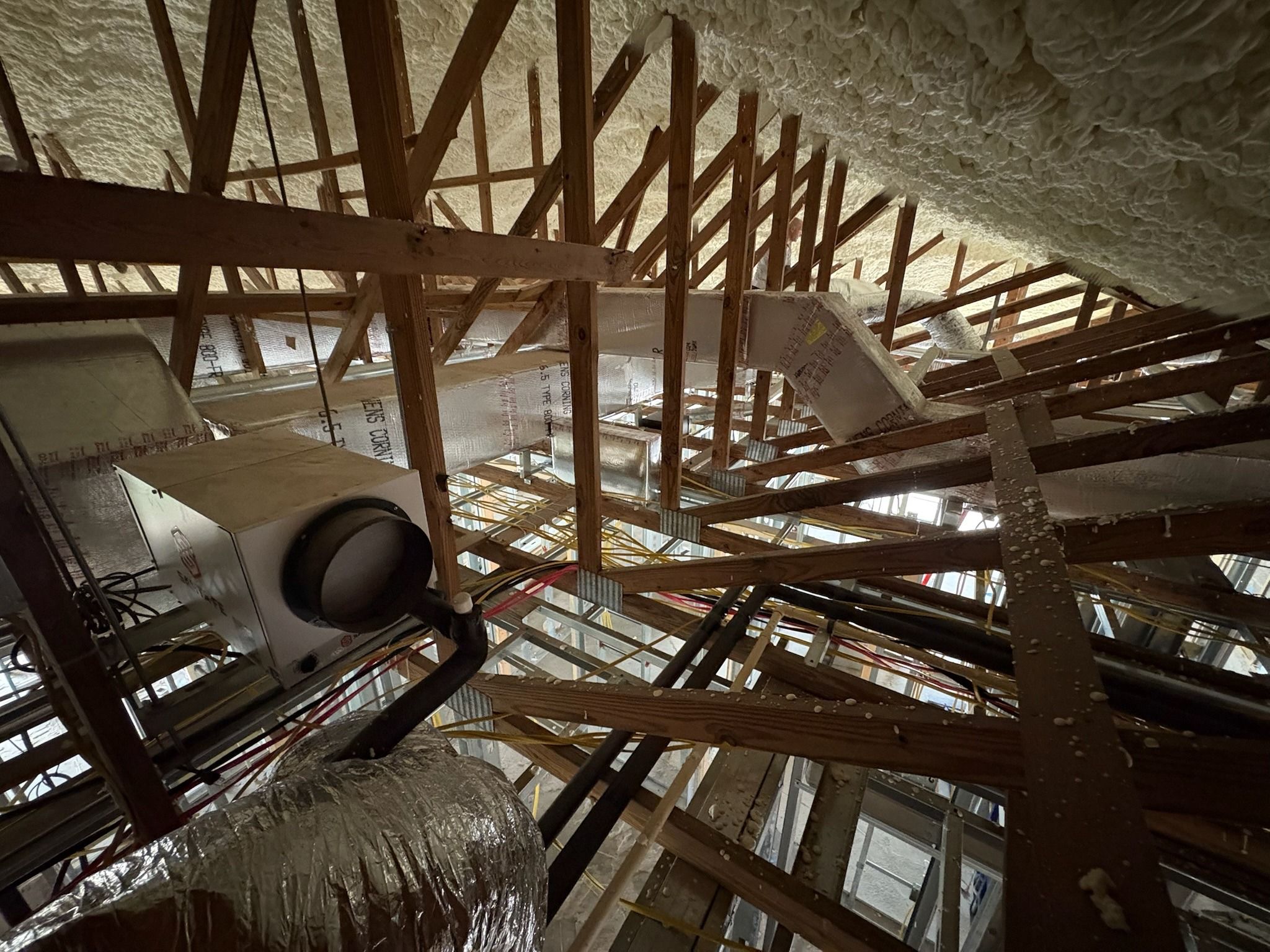 Air handler hung among trusses in a spray-foamed attic