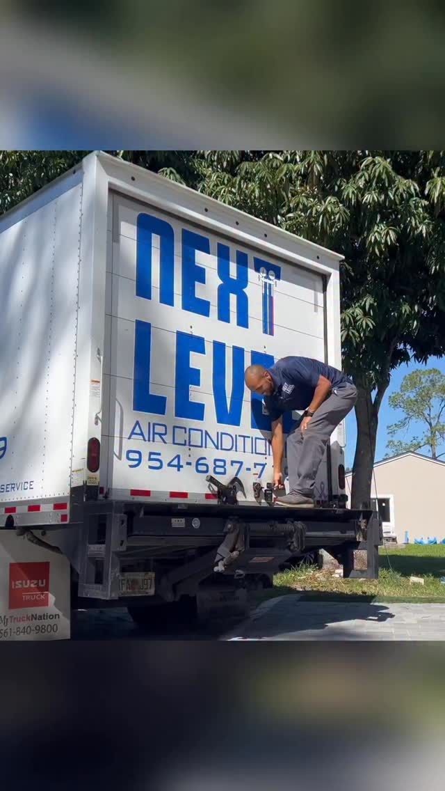 Technician stepping down from the liftgate of the branded box truck