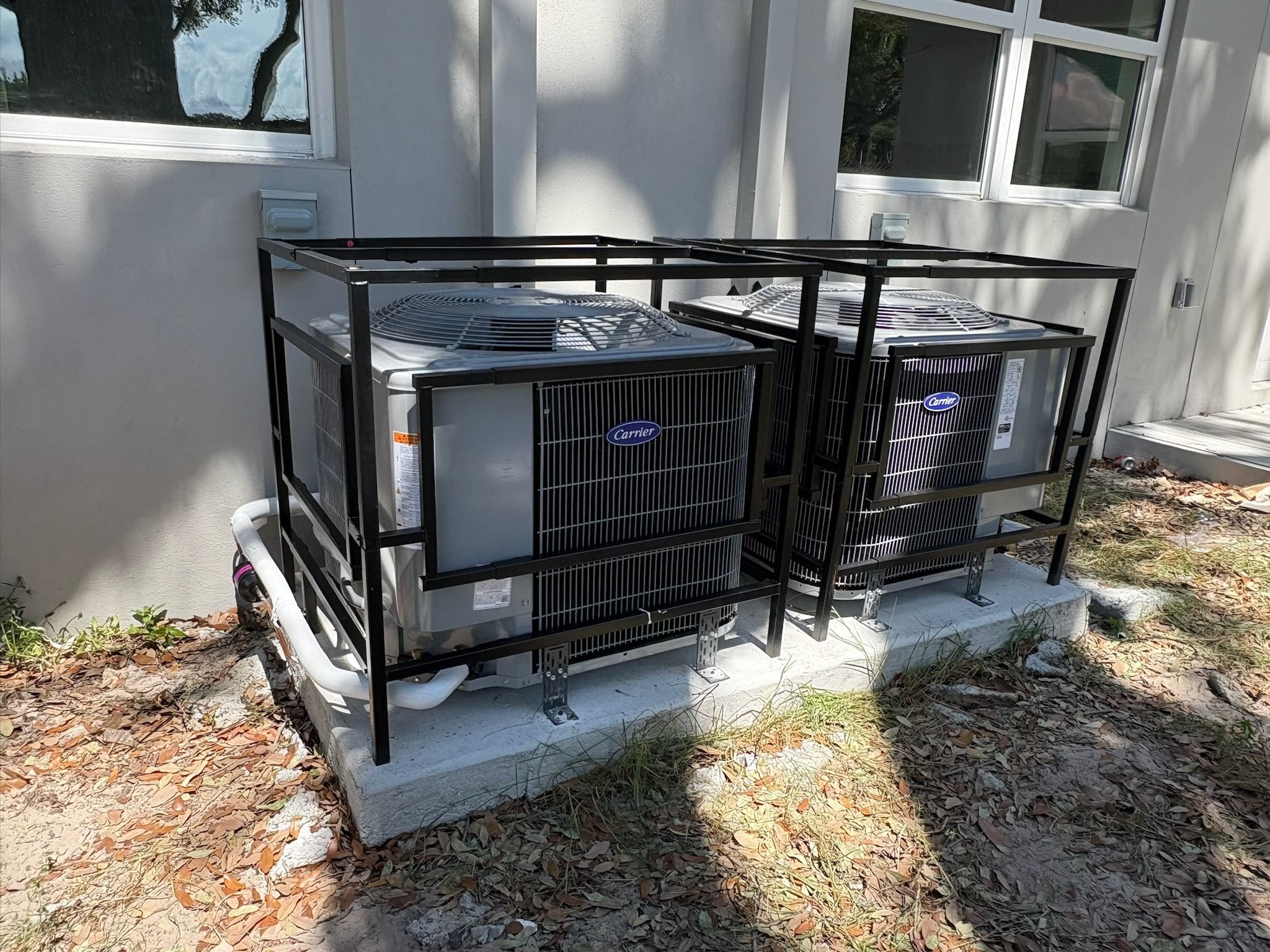 Two Carrier condensers inside security cages on a concrete pad