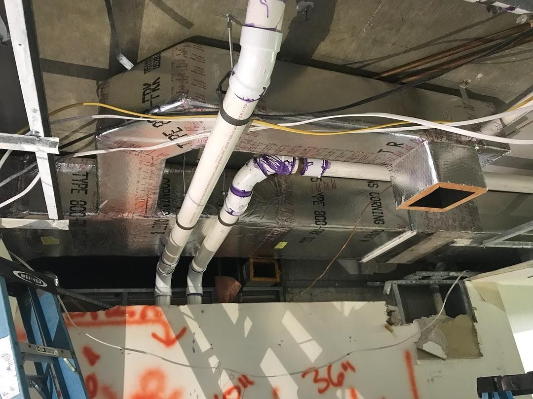 Insulated duct board plenum and PVC condensate lines roughed in above a ceiling