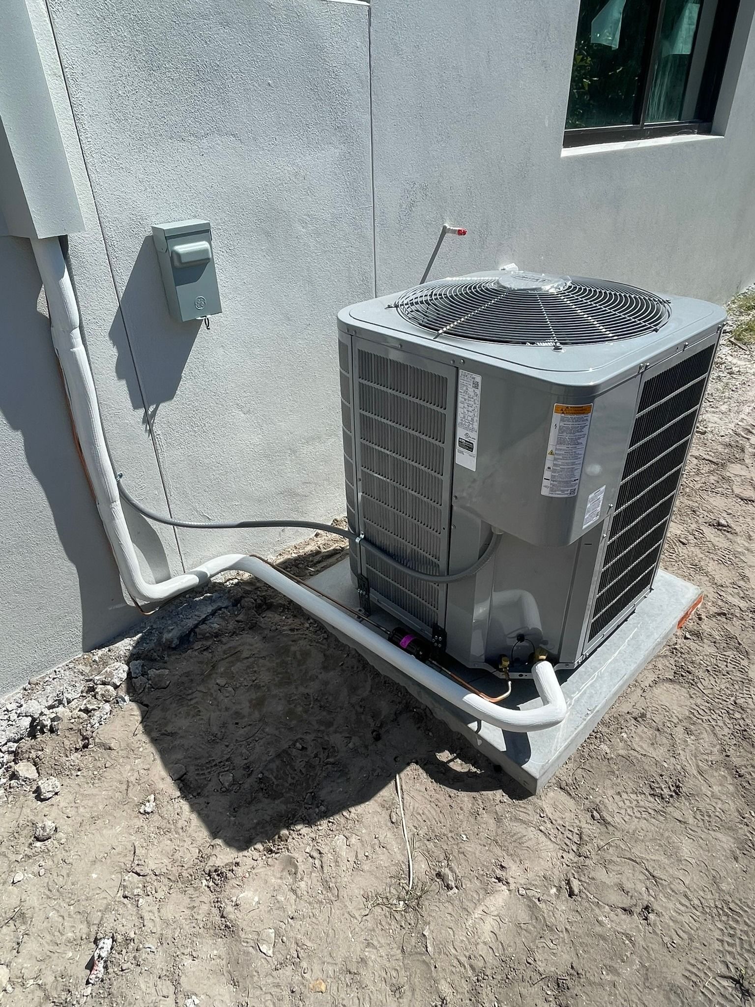 Condenser on a new pad beside a new home