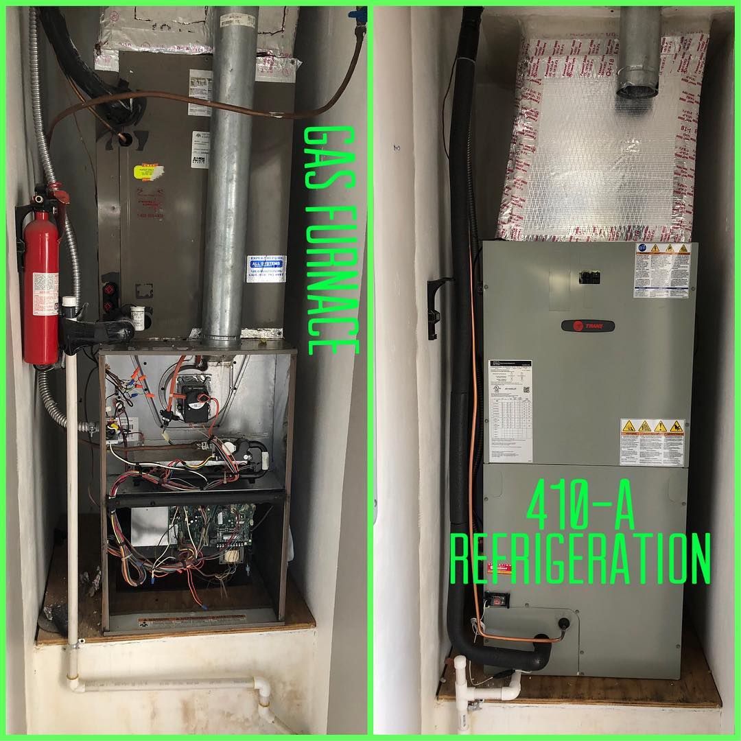 Opened gas furnace with its flue beside a Trane air handler on the same job