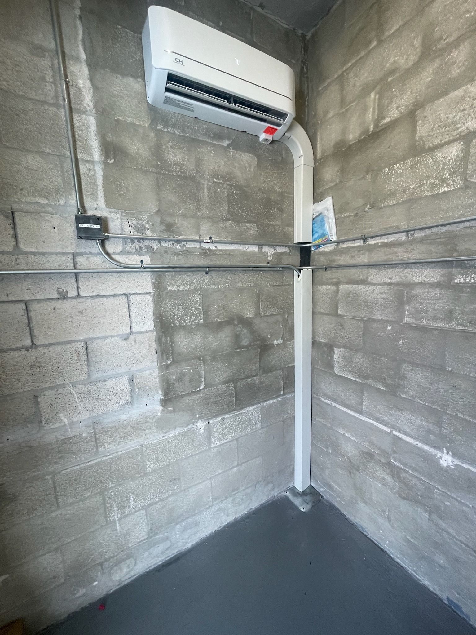 Mini-split indoor head mounted high on a block wall