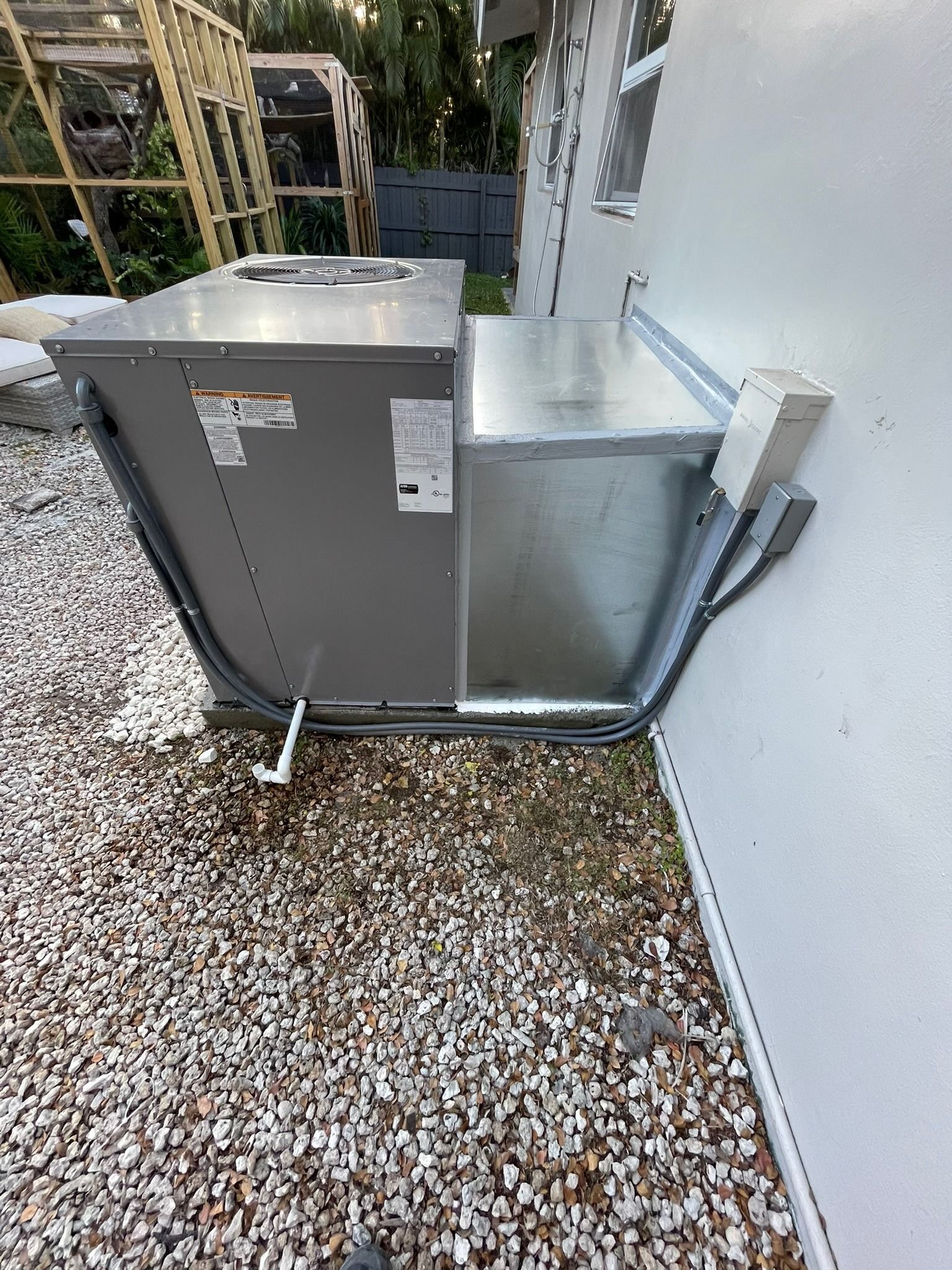 Packaged unit beside a home on a gravel bed