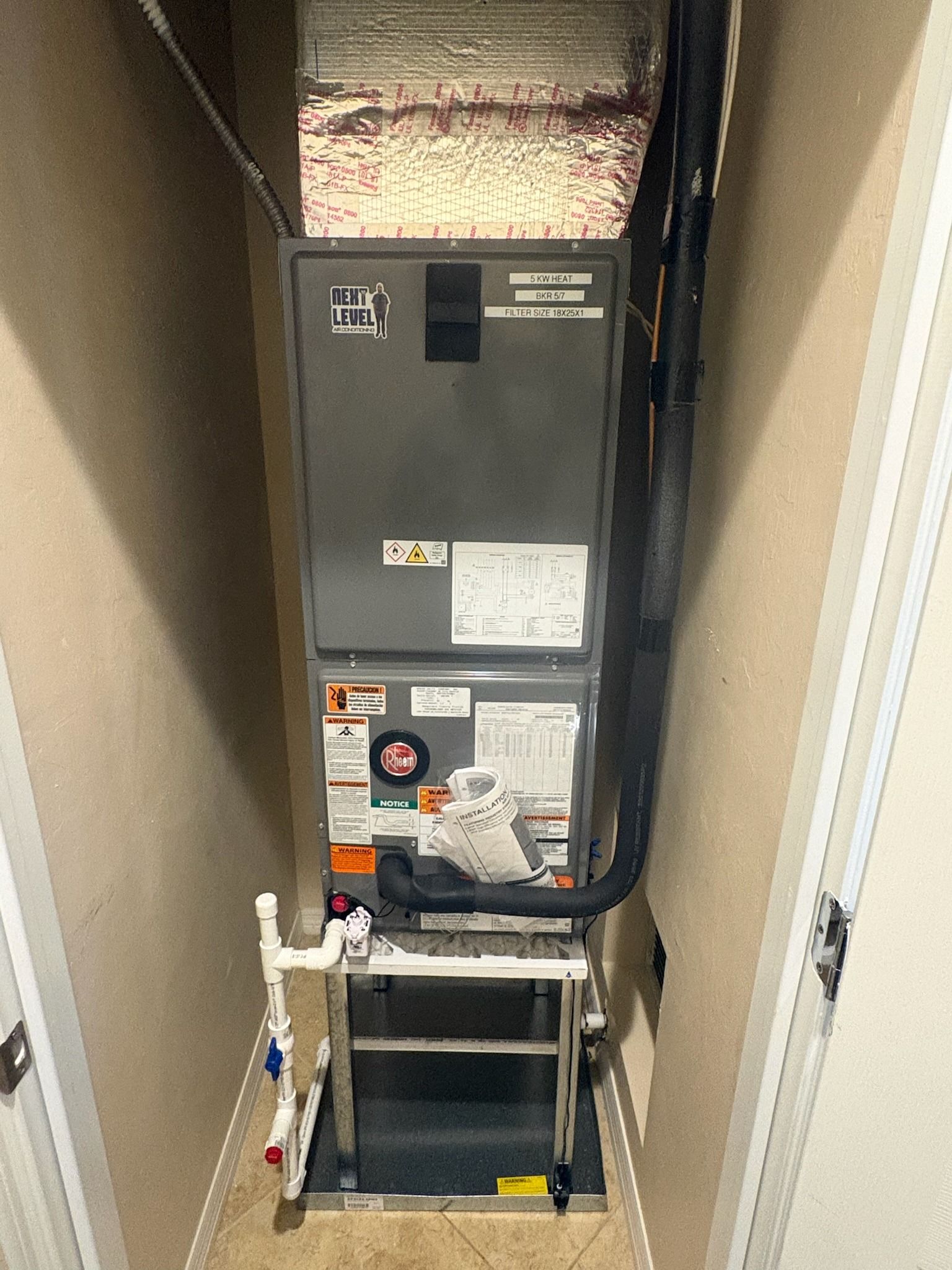 Rheem air handler on a stand in a hallway closet, Next Level Air Conditioning job in Lake Worth, 2026
