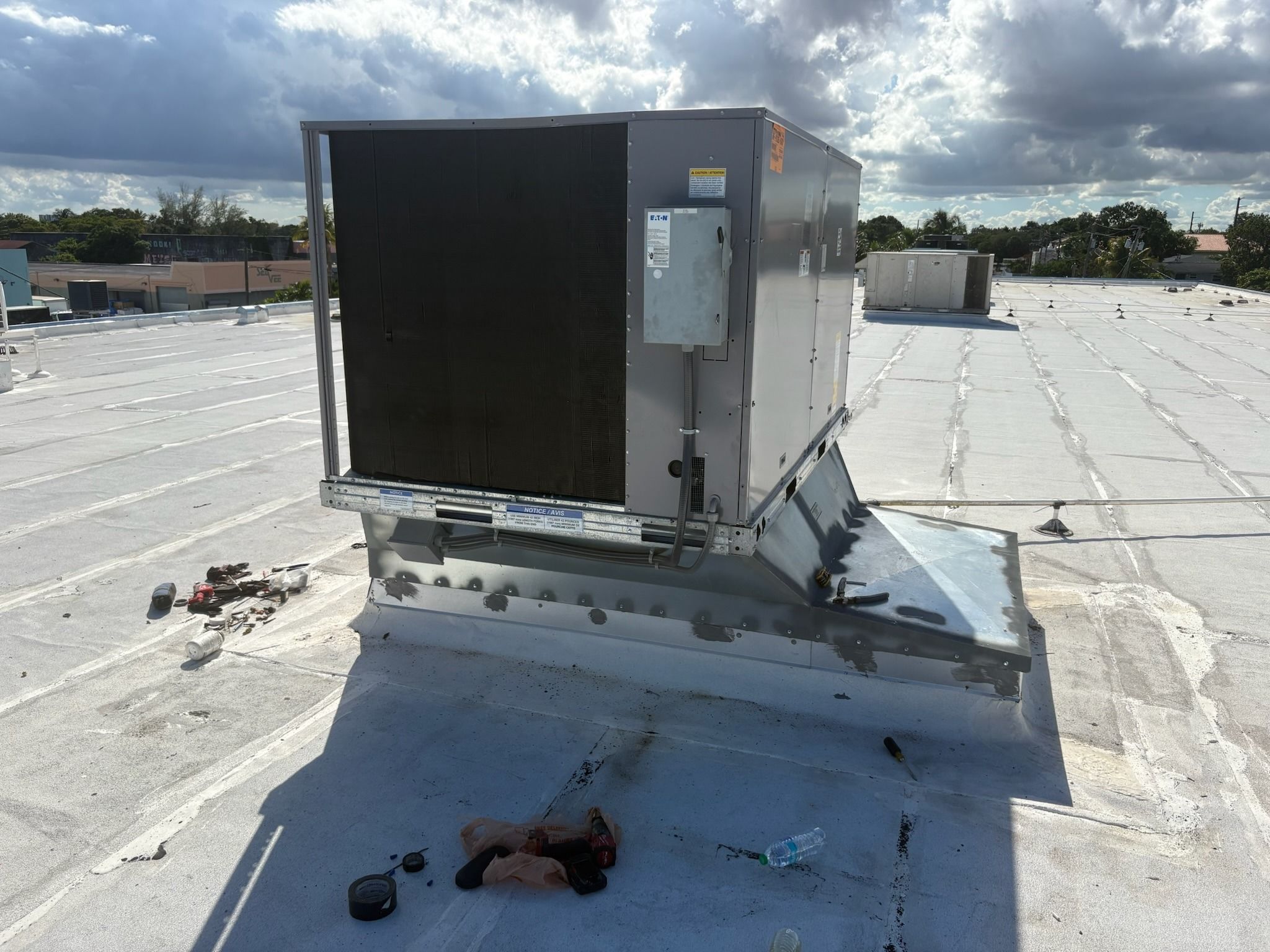 Rooftop package unit set on a curb on a flat commercial roof