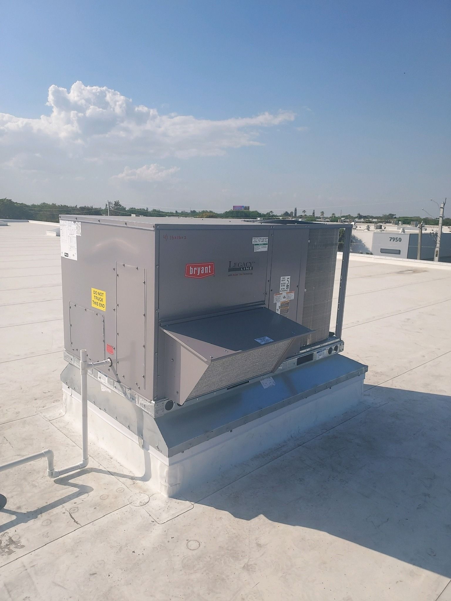 Rooftop package unit set on a new curb on a flat commercial roof