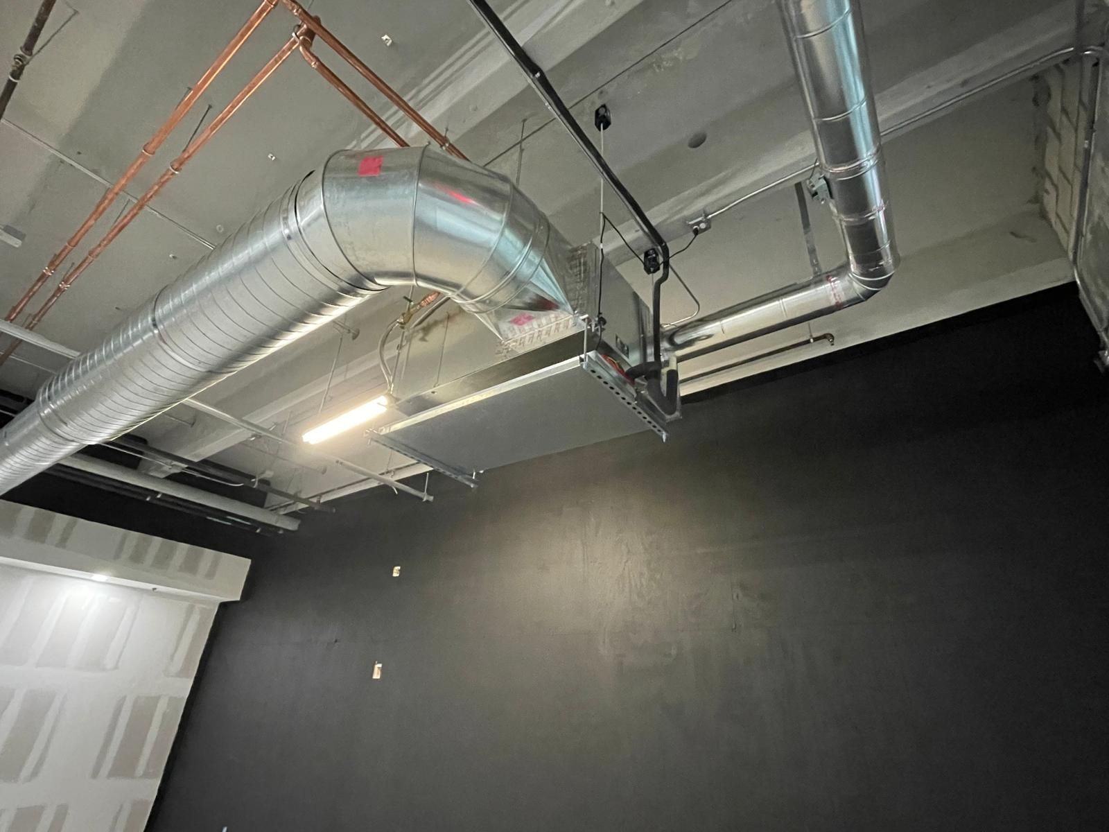 Spiral duct with a large elbow in a finished commercial room