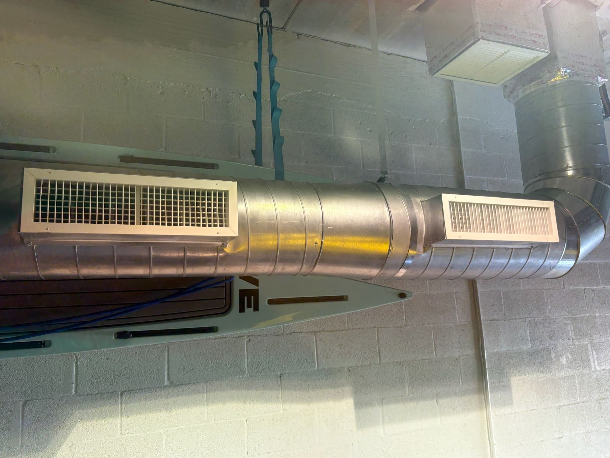 Spiral duct with two supply grilles under a concrete ceiling